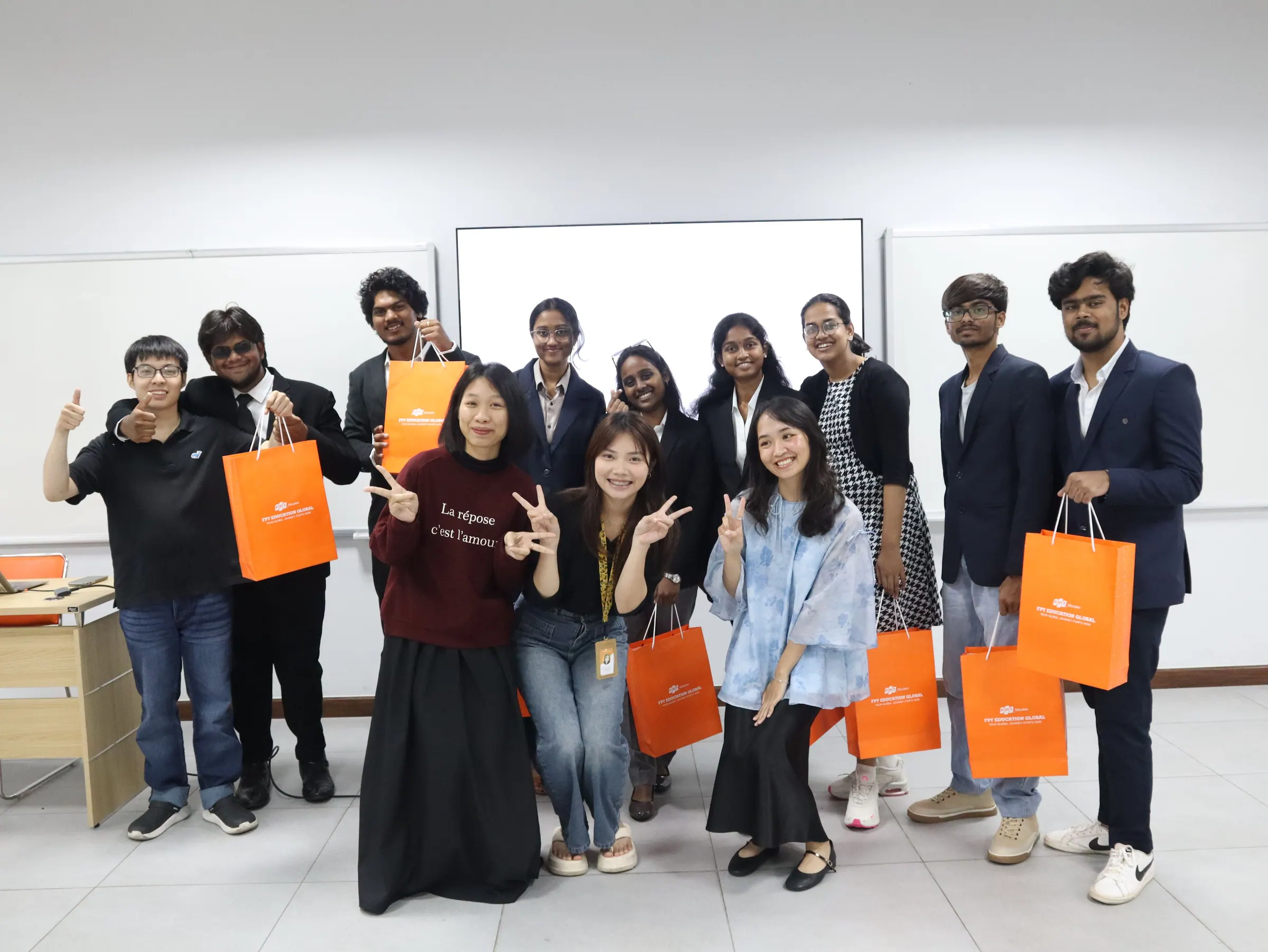 The group posing together holding orange gift bags
